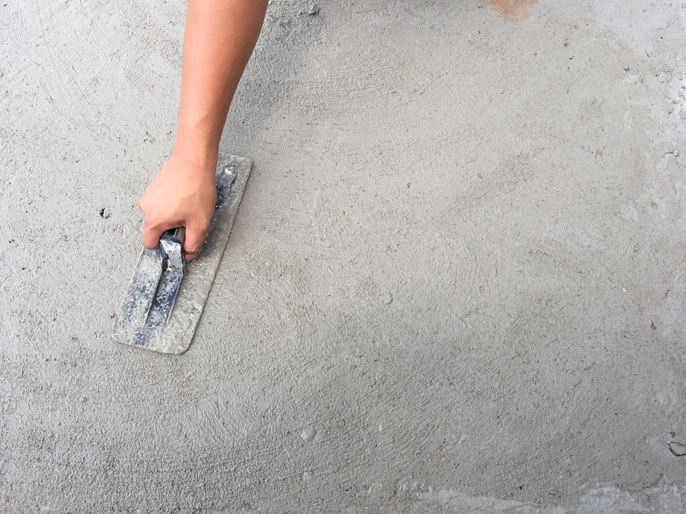 Plasterer smoothing fresh render with a steel trowel before painting in Newcastle