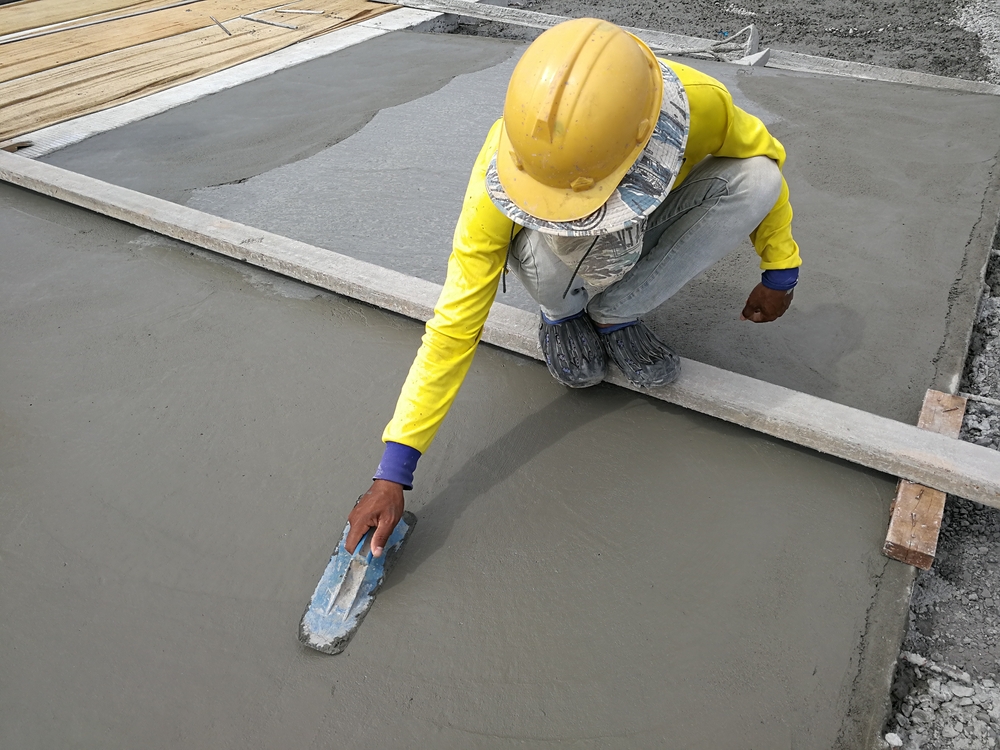 Tradesperson trowelling a fresh screed smooth on a Cessnock plastering job