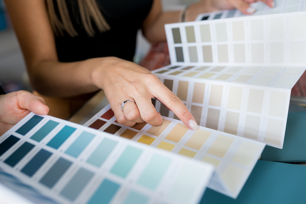 Homeowner and decorator comparing paint colour swatch fans while planning an interior decorating project in Central Coast