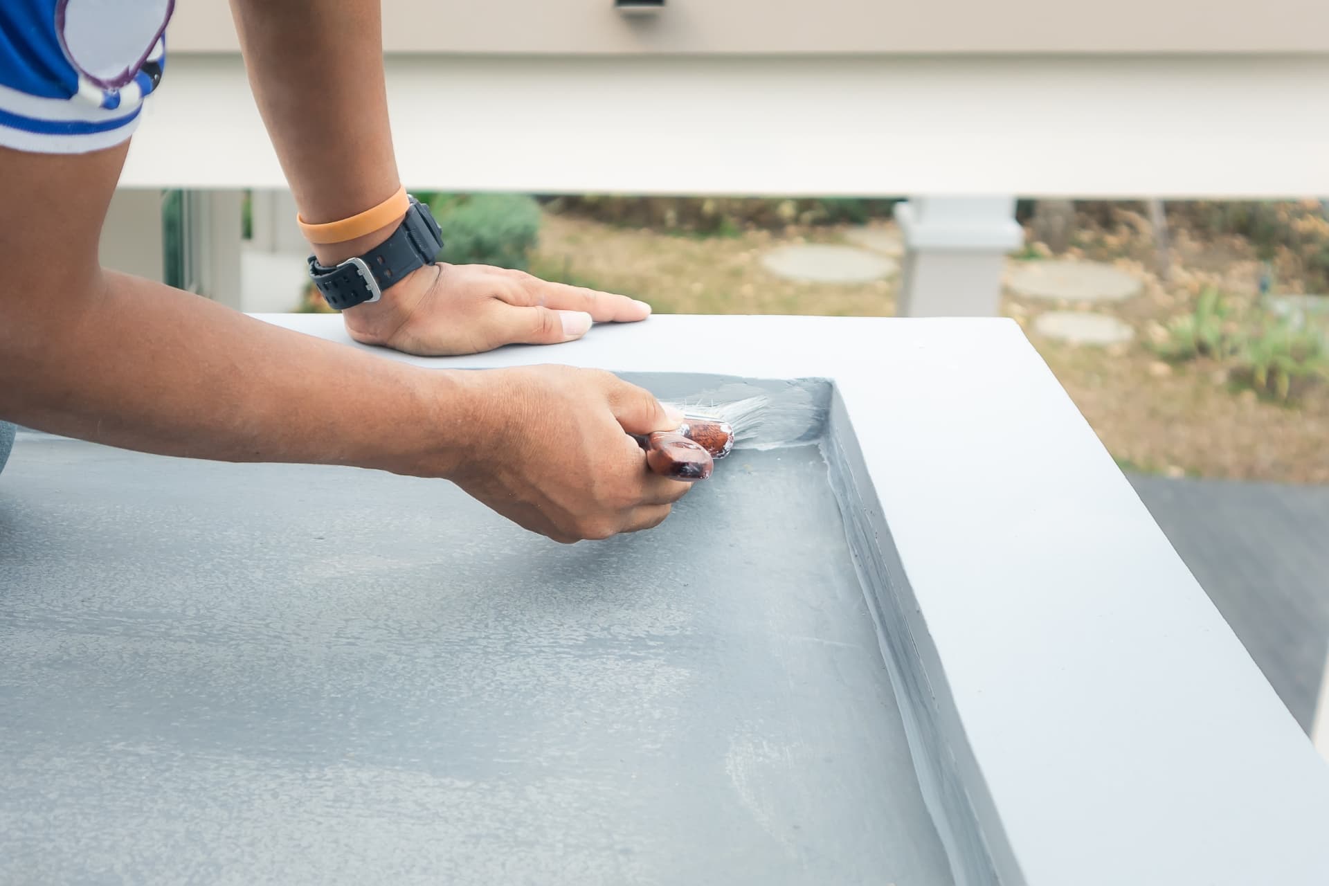 Commercial painter cutting in a brushed edge on a rendered surface in Newcastle