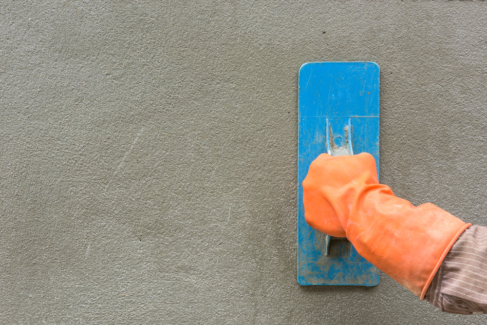 Plasterer floating a rendered wall smooth ready for painting in Maitland