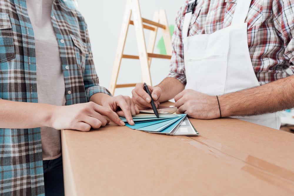 Painter and homeowner comparing colour swatches while planning an interior decorating project in Cessnock