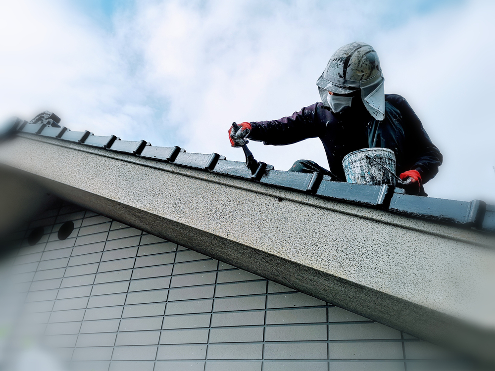 Painter coating a roof ridge line on a Hunter Valley home