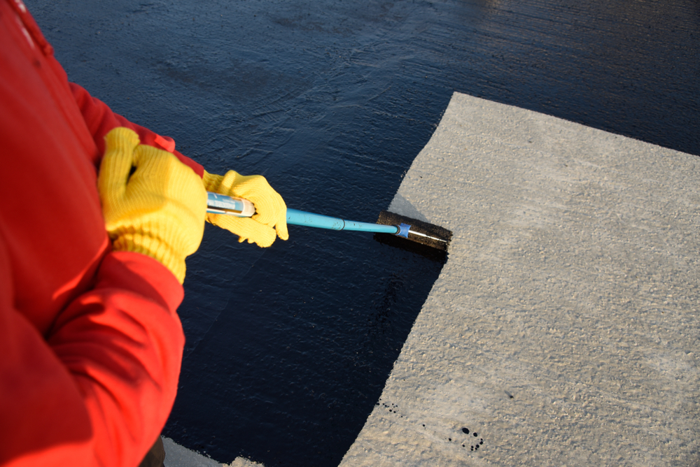 Tradesperson applying a protective coating to a concrete surface on a commercial job in Port Stephens